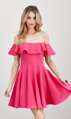 Model wearing the Off-the-Shoulder Short Party Dress in bright pink with ruffles, holding the skirt’s sides while standing against a plain light background.
