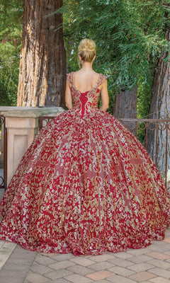 A woman wearing the Quinceanera Dress 1670 By Dancing Queen stands outdoors with her back to the camera, facing a railing and towering trees.