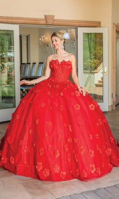 A woman smiles in front of open glass doors wearing the Dancing Queen Quinceanera Dress 1704, a strapless ball gown adorned with floral appliqués.