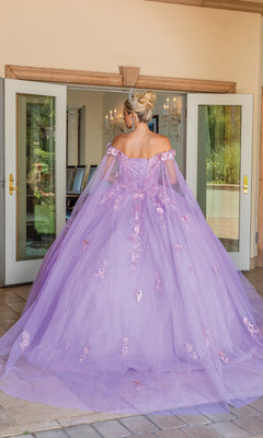 A person in the Quinceanera Dress 1714 By Dancing Queen, a lilac off-the-shoulder gown with floral appliqués, stands facing away in front of open double doors.