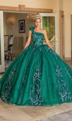 A woman stands in a doorway wearing the Dancing Queen 1733, a one-shoulder long quinceañera dress with silver embroidery and a corset back.