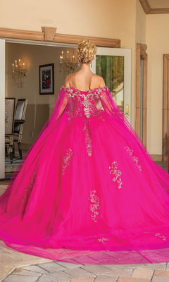 A person with an updo stands indoors, back to the camera, wearing Quinceanera Dress 1740 By Dancing Queen—a bright pink off-the-shoulder gown adorned with silver embroidery.