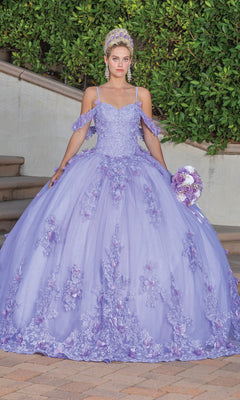 A young woman stands outdoors in the Quinceanera Dress 1747 By Dancing Queen, featuring lilac floral details and a matching tiara, holding a round bouquet with green bushes and steps in the background.