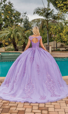 A woman stands by a pool, back to the camera, wearing the Quinceanera Dress 1758 By Dancing Queen—a floor-length lavender a-line ball gown with glitter lace embroidery—surrounded by palm trees and greenery.