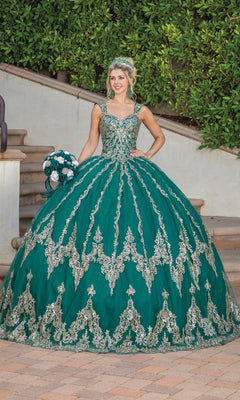 A young woman stands outdoors on stone steps surrounded by greenery, wearing the Quinceanera Dress 1779 By Dancing Queen—a hunter green ball gown with lace embroidery and a sweetheart neckline—paired with a tiara and bouquet.