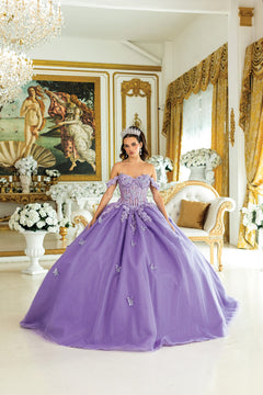 Woman in a purple ball gown standing in an elegant room with gold accents and decorative elements.