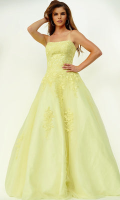 A woman stands against a plain light background wearing the Jovani 1831 long formal dress in light yellow, a strapless, floor-length ballgown adorned with floral lace applique embellishments.