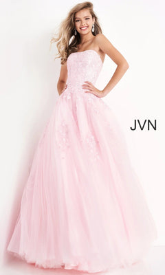 A woman stands against a white background wearing the Jovani 1831 long formal dress in light pink—a strapless, floor-length gown featuring a fitted bodice and floral embellishments.