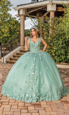 A woman stands on a brick pathway in front of a gazebo, wearing the Quinceanera Dress 1831 By Dancing Queen—a sage green gown with floral embroidery, a full A-line skirt, and an enchanting fairytale silhouette.