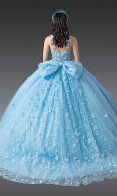A woman is shown from behind against a plain gray background, wearing the Quinceanera Dress 1879 by Dancing Queen—a pastel ball gown adorned with butterfly appliqués, featuring a large back bow and a matching headpiece.