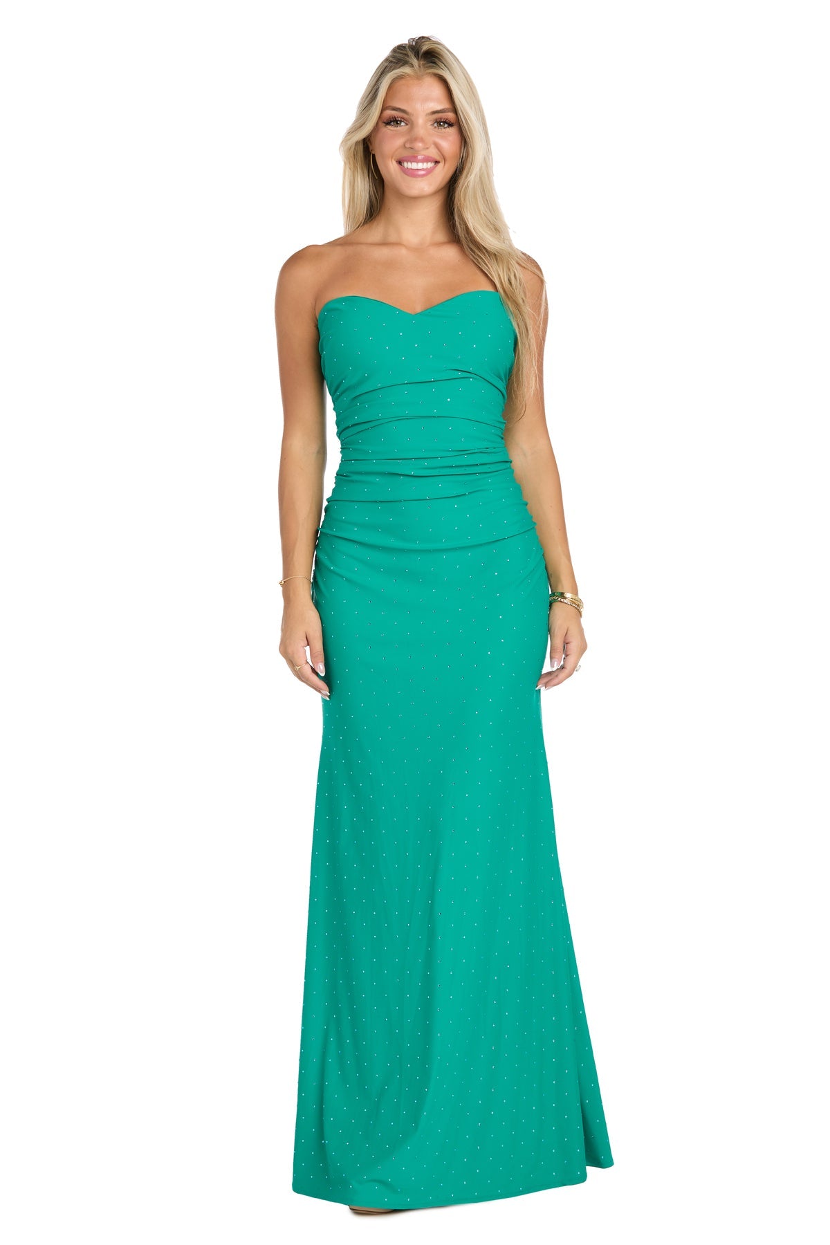 Woman standing and smiling in the Jade Green Long Ruched Prom Dress, Morgan 19016—a strapless evening gown with a subtle polka dot pattern.