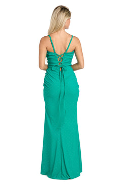 A woman stands with her back to the camera, wearing the Morgan 19016 jade green long ruched prom dress with thin straps and a lace-up back.