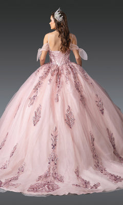 A woman faces away on a gray background, wearing the Quinceanera Dress 1902 by Dancing Queen—a pink tulle ballgown featuring off-the-shoulder sleeves and an embellished bodice adorned with sequin accents.