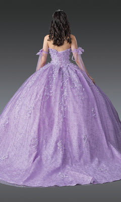 A person with curly dark hair is shown from the back against a plain gray background, wearing the Quinceanera Dress 1905 by Dancing Queen—a sparkling lilac gown featuring off-shoulder tulle sleeves and a fitted corset bodice.