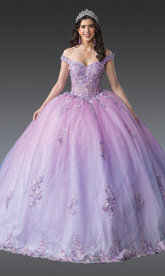 A woman wearing the Quinceanera Dress 1906 by Dancing Queen in lilac, featuring an off-the-shoulder design with 3D floral appliques, accessorized with a tiara and earrings, stands against a plain gray background.