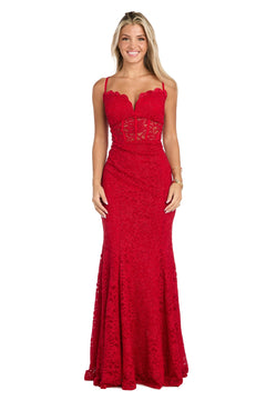 A woman stands against a plain white background wearing the Long Red Lace Prom Dress: Morgan 19069, a sleeveless, floor-length gown featuring a fitted bodice and sheer corset detailing.