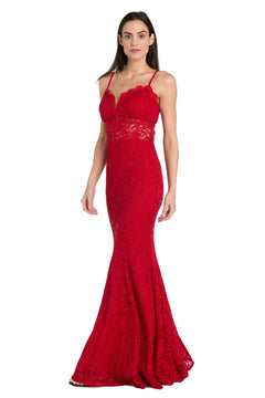 A woman models the Morgan 19069 long red lace prom dress, a floor-length, form-fitting gown with thin straps and a sheer lace midsection, standing against a plain white background. This elegant mermaid style highlights her silhouette.