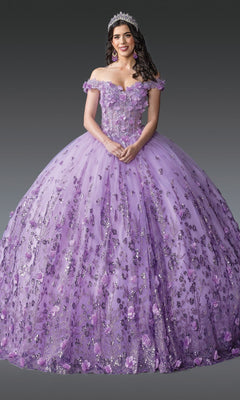 A woman wearing the Quinceanera Dress 1908 by Dancing Queen in lilac, featuring delicate 3D floral appliques and off-the-shoulder sleeves, accessorized with a jeweled tiara and earrings, stands against a plain gray background.
