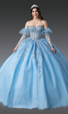 A woman wearing the Quinceanera Dress 1910 by Dancing Queen in Bahama Blue, featuring a silver-embroidered corset bodice, off-the-shoulder tulle sleeves, and a tiara, stands against a gray background.