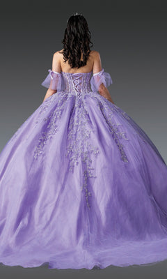 A person wearing the Quinceanera Dress 1910 By Dancing Queen, featuring a purple off-shoulder design with floral embroidery, stands facing away against a plain dark background; the ball gown skirt flows elegantly while the embellished corset bodice adds an intricate touch.