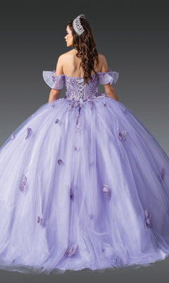 A woman stands against a plain gray background wearing the Quinceanera Dress 1911 by Dancing Queen—an off-shoulder lavender ball gown adorned with delicate butterfly appliques, featuring a dramatic ballgown skirt, a lace-up back, and paired with a silver tiara.
