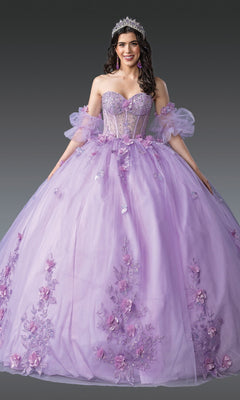 A woman wears the Quinceanera Dress 1949 By Dancing Queen—lilac glitter tulle with floral appliqués and puffed sleeves—plus a tiara and earrings, standing against a gray background.