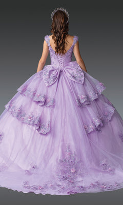 A woman with long brown hair, shown from the back, wears the Quinceanera Dress 1952 By Dancing Queen—a lilac gown with floral lace embroidery, layered skirts, a large back bow, and a jeweled headpiece.