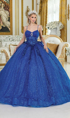 A woman in the Long Quinceañera Dress with Bow: Dancing Queen 1958 and a tiara stands in an ornate gold and white room, posed before a sofa and elegant floral arrangements.