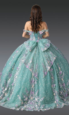 A woman with wavy brown hair faces away, wearing the Quinceanera Dress 1962 by Dancing Queen in teal with a floral design, large bow, and off-the-shoulder sleeves against a gray background.