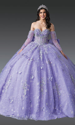 A woman wears the Quinceanera Dress 1965 By Dancing Queen—a sparkling lavender gown with floral embroidery, sheer sleeves, and a tiara—standing gracefully against a gray background.