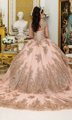 A woman wearing the Quinceanera Dress 1968 by Dancing Queen, featuring pink fabric with gold embroidery and sparkly embellishments, stands in an ornate room with gold accents, white flowers, and classical decor, facing away from the camera.