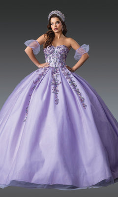 Woman wearing the Lilac Quinceanera Dress 1977 by Dancing Queen, featuring purple glitter tulle, floral and beaded embroidery, sheer puff sleeves, and a jeweled tiara—perfect for a modern quinceanera look against a gray background.