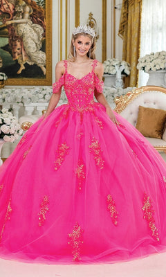 A woman wearing the Hot Pink Quinceanera Dress 1983 By Dancing Queen, featuring gold embellishments and a corset bodice, smiles in an ornate, flower-filled room with a sparkling tiara.