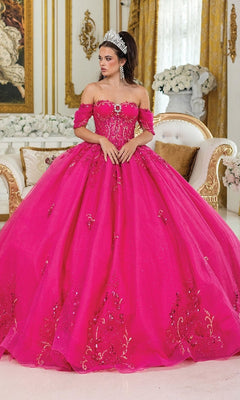 A woman in the Pink Quinceanera Dress 1987 by Dancing Queen, featuring a fuchsia hue and corset bodice with sparkling details, stands in an ornate gold-accented room decorated with flowers.