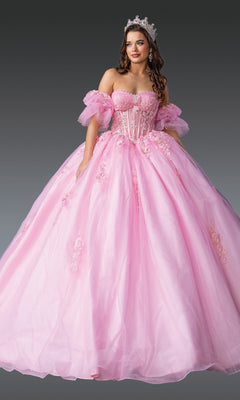 A woman in the Pink Quinceanera Dress 1988 By Dancing Queen, featuring lace embroidery, floral details, and a tiara, poses against a gray background in an elegant off-the-shoulder ball gown.