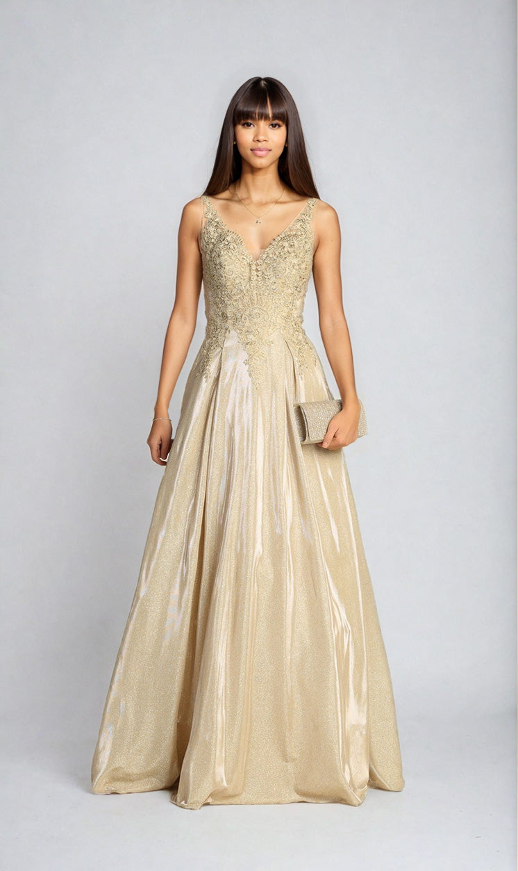 A woman stands facing forward in the Lace-Bodice Long Glitter Prom Dress Chicas DM4017, featuring a sleeveless fitted embellished bodice and flowing skirt, holding a gold clutch against a plain light background.