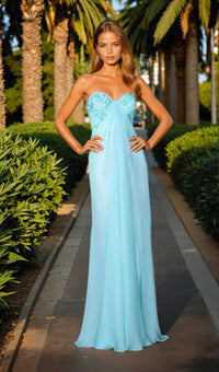 Woman in a light blue evening gown standing outdoors with palm trees in the background