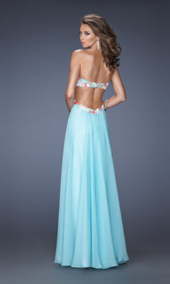 A woman faces away in the La Femme Multicolor-Lace Chiffon Prom Dress 20059, featuring a long, light blue open-back design with delicate floral lace trim, set against a plain gray background.