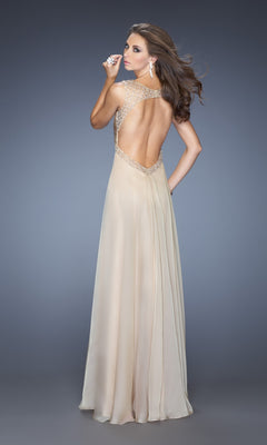A woman models the La Femme Dress 20122, a floor-length sleeveless chiffon gown with embellished straps and open back, posing against a plain gray background while looking over her shoulder.