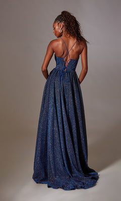 A woman faces away from the camera in the Lace-Up Long Glitter Prom Dress: Aerie Couture 201, a floor-length dark blue gown with thin cross-back straps and a sparkling, flowing skirt.