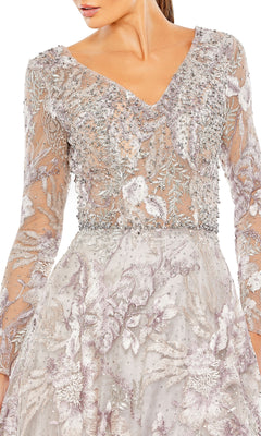 A woman wears the Mac Duggal 20214 long sleeve formal dress, featuring silver and lavender hues with intricate beadwork and floral embroidery.