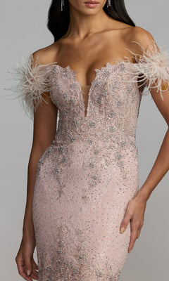 A woman is wearing the Mac Duggal 20246 off-shoulder long formal dress, featuring light pink fabric, beaded embellishments, feathered sleeves, and intricate sparkling details.