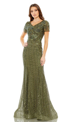A woman wears the Long Formal Dress 20282 by Mac Duggal, a floor-length, olive green lace gown with short sleeves, sequin accents, and a flattering v-neckline, standing against a white background.