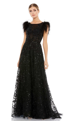 A woman wears the Mac Duggal 20296 Feather Long Black Formal Dress, a floor-length gown with sheer details, beaded embellishments, feathered shoulder accents, and embroidered lace for an elegant look.