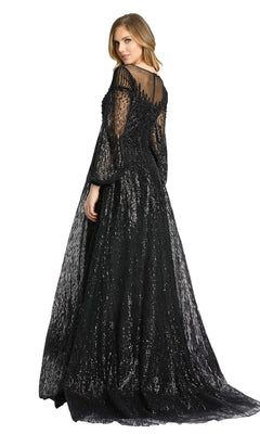 A woman models the Mac Duggal 20307 Long Sleeve Sequin Formal Gown, featuring sheer sleeves and back, standing slightly turned to the side against a white background.