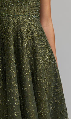 Close-up of a person wearing the Tea Length Lilac Party Dress by Mac Duggal (style 20338), featuring cap sleeves and intricate beaded detailing, set against a plain gray background.