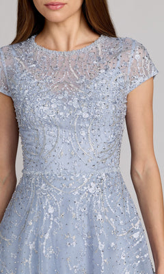 A woman wearing the Tea Length Lilac Party Dress by Mac Duggal (20338), featuring intricate sequin and bead embellishments on sheer fabric.
