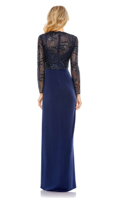 A blonde woman wears the Mac Duggal 20340 long sleeve blue formal dress with a sheer, sequined lace back and floor-length skirt, shown from behind.