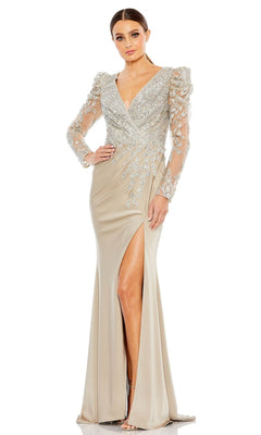 A woman wears the Long Formal Dress 20346 by Mac Duggal in champagne, featuring silver embroidery, sheer sleeves, a deep V-neckline, and a high front slit.