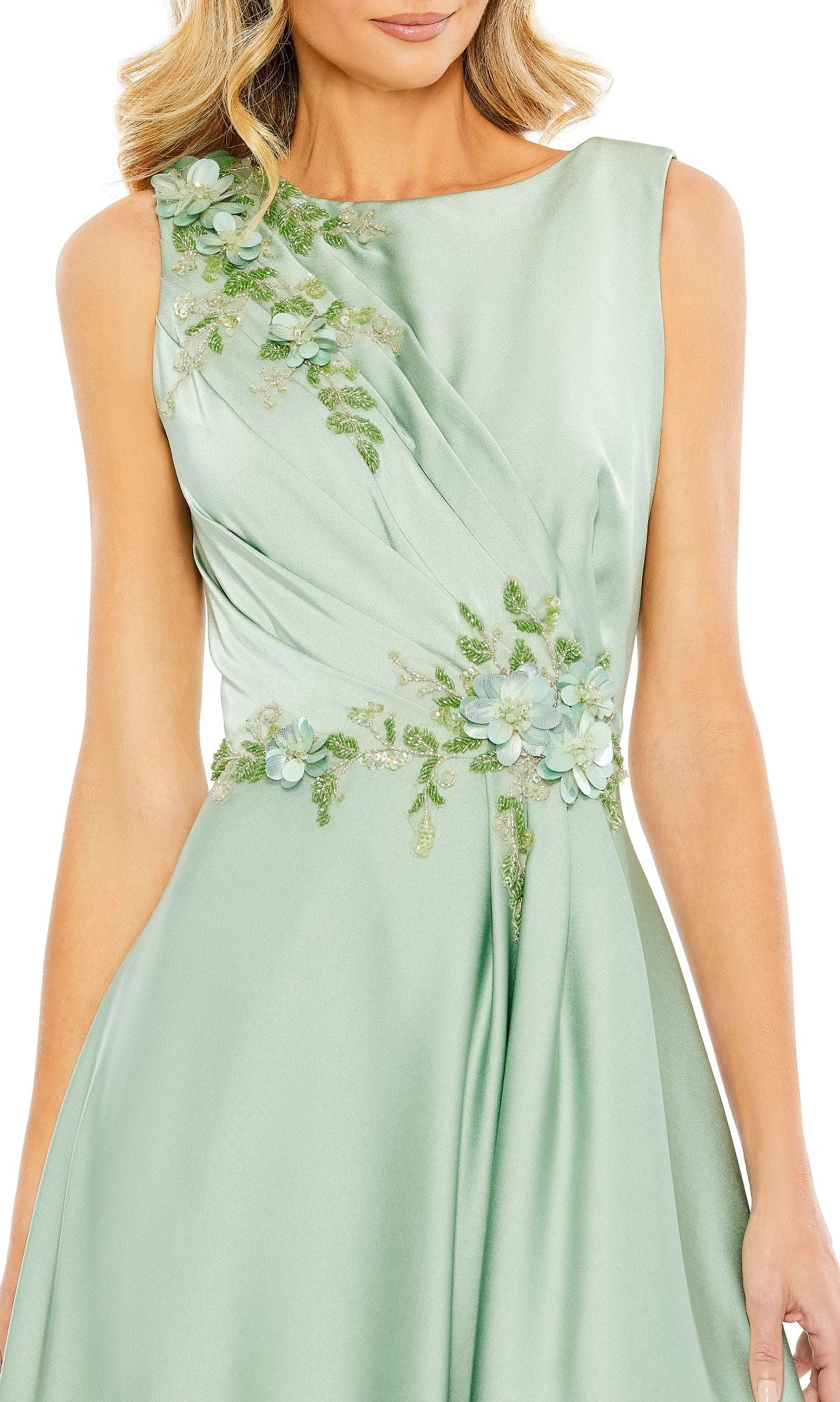 A woman wears the Mac Duggal 20365, a sleeveless long formal dress in light green satin with floral embroidery and 3D flower appliqués—an elegant evening gown choice.